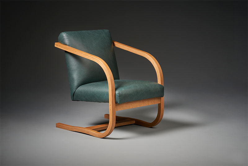 modern chair with leather seat and curved wood arms