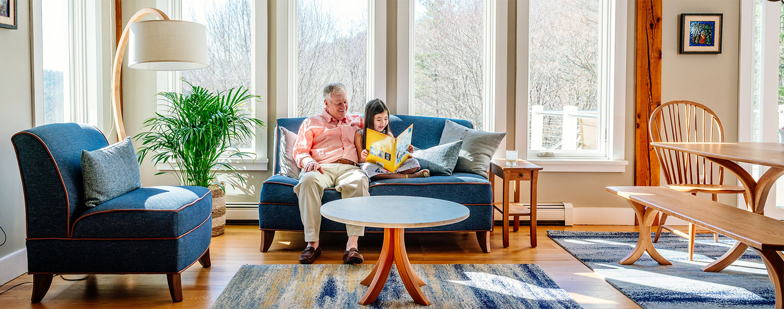 grandfather and daughter reading on a blue couch