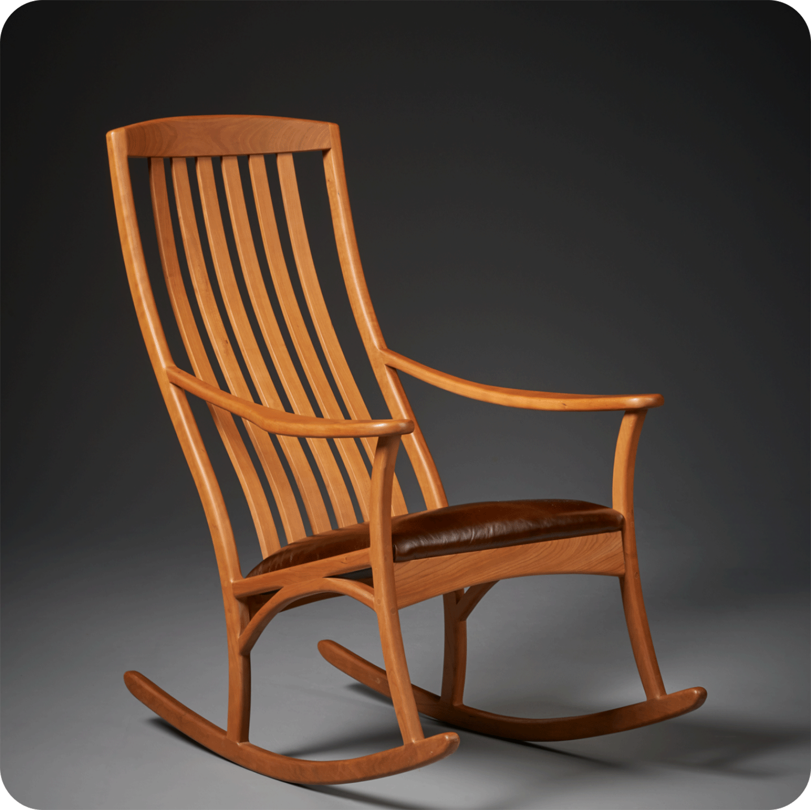 a cherry rocker with leather seat